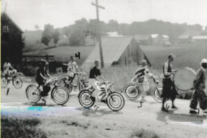 Old photo from 1937 with several boys on bikes and one with a drum